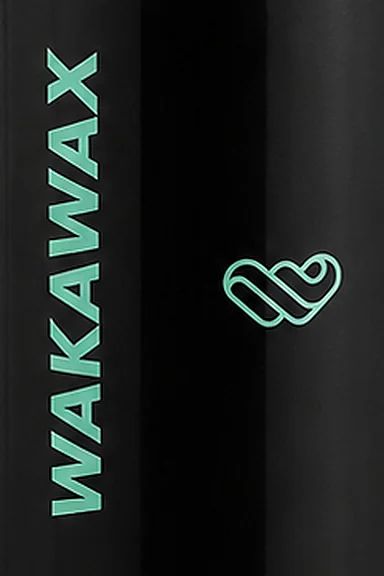 The vertical WakaWax wordmark and logo on the black bottle